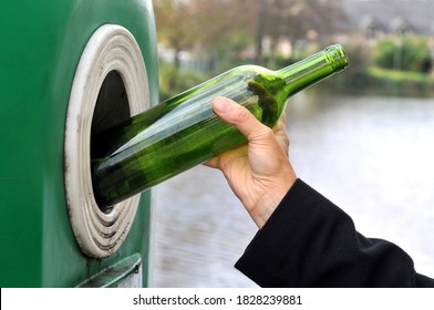 Throwing A Glass Bottle In A Recycling Bin Close Up 