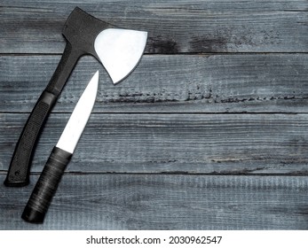 A Throwing Hatchet, A Tomahawk And A Hunting Knife On A Wooden Background Of A Table Made Of Boards. Free Space For Copying And Pasting.