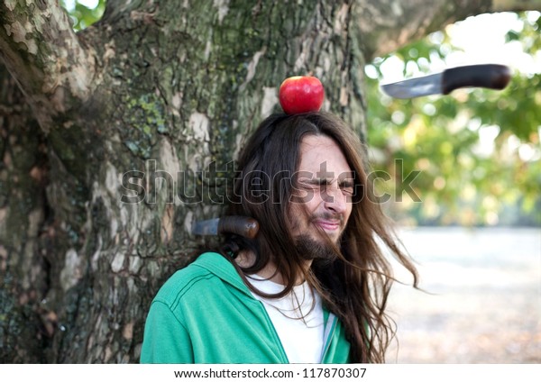 Throwing knife into\
apple on a guy\'s head