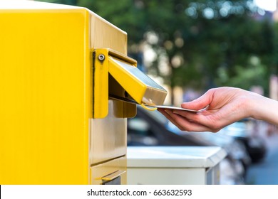 Throwing A Letter In A German Yellow Mailbox