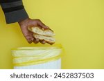 throwing old breads in a garbage bin 