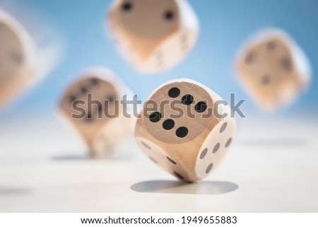 Throwing and rolling many wooden dice on a blue background