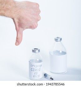 Thumb Down For Bad Vaccine In Glass Medical Bottles On A White Background.