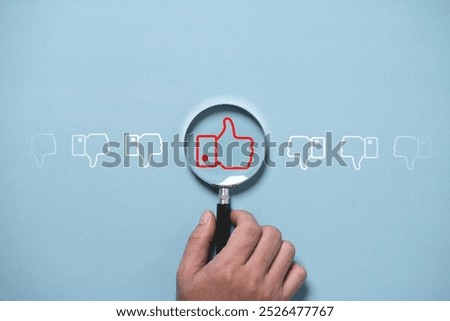 Thumb up or like button inside of magnifier glass among thumb down.