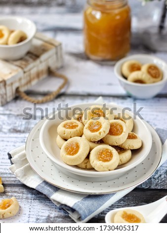 Thumbprint cookies filled with pineapple jam. Photographed with natural light. Selective Focus. White textured background