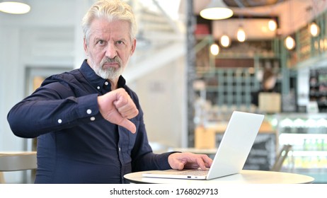 Thumbs Down By Old Man Using Laptop In Cafe