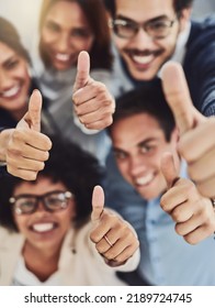Thumbs up from a happy business team excited about the success they achieve together at work. Overhead view diverse group of corporate people excited by success and give approval to winning - Shutterstock ID 2189724745