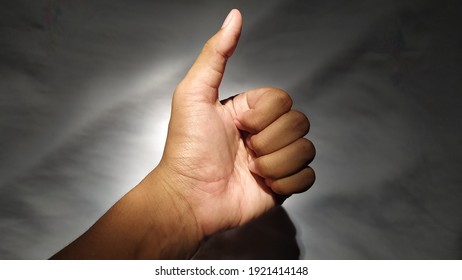 Thumbs up in the light in the dark