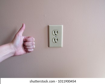 Thumbs Up Next To An American Wall Outlet