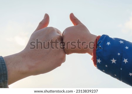 Thumbs Up Sign with Child and Father's Hand. Sky background.
Like sign.