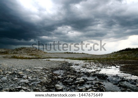 Thunder clouds roll in over a shallow creek in Frisco, TX