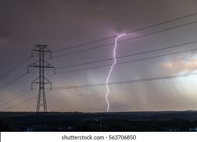A thunder and lightning storm in the background with a Silhouette of a hydro tower. Two sources of power one man made the other nature