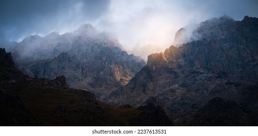 Thunder warning in the mountains, picturesque majestic rocky mountains scenery with an impending storm and the last light of the sun at sunset, wild nature without people.
