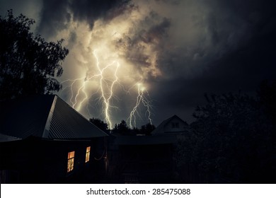 Thunderbolt Over The House And Dark Stormy Sky On The Background