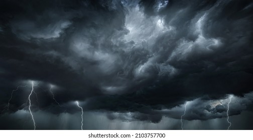 Thunderous dark sky with black clouds and flashing lightning. Panoramic view. Concept on the theme of weather, natural disasters, storms, typhoons, tornadoes, thunderstorms, lightning, lightning.