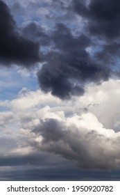 Thunderstorm clouds texture. Storm sky with dark grey and white cumulus clouds against blue sky background