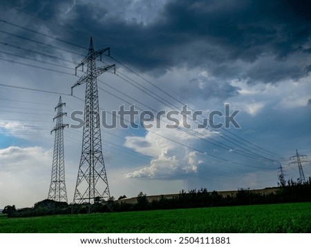 Thunderstorms and rain clouds over high-voltage pylons