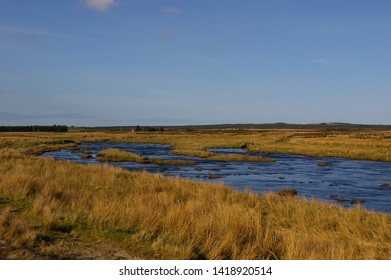 The Thurso River flowing through the flat countryside near Westerdale in the Scottish Highlands.