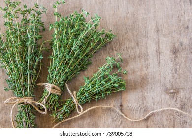 Thyme bunch. Bundle of fresh thymes on a wooden background. - Shutterstock ID 739005718