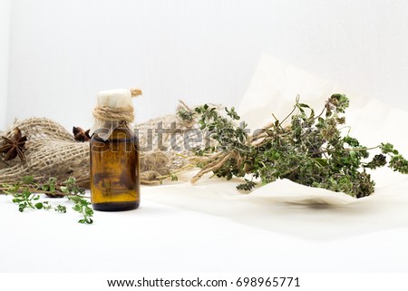 Thyme oil skincare. Bottle of herbal extract, aromatic fresh green twigs