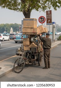 TIANJIN, CHINA - 22 OCTOBER 2018: Local chinese man with overloaded bike on bridge in Tianjin