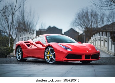 TIANJIN, CHINA - FEB 27, 2016: A red Ferrari 488 GTB parked in front of a stone bridge. The Ferrari 488 is an Italian sports car produced since 2015, powered by a 3.9-litre twin-turbocharged V8.