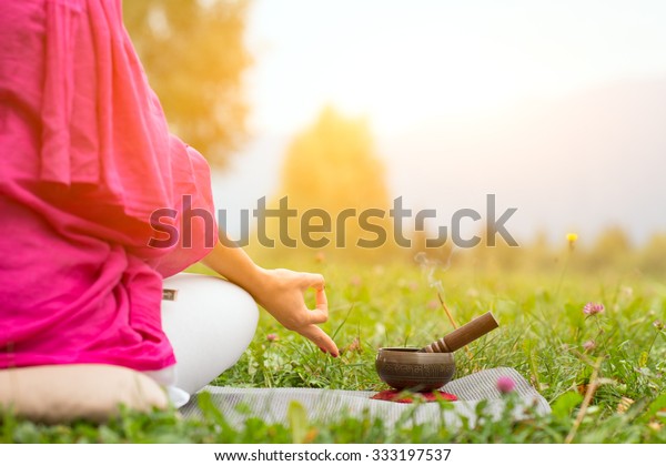 Tibetan\
bell beside yoga position in a meadow the\
sun