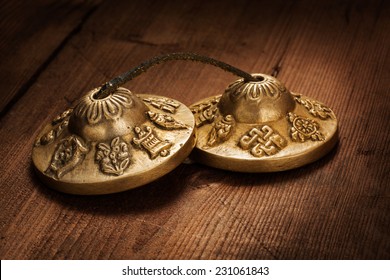 Tibetan Buddhist tingsha cymbals on wooden background