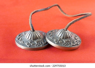 Tibetan cymbals or Ting-sha, isolated on red background.