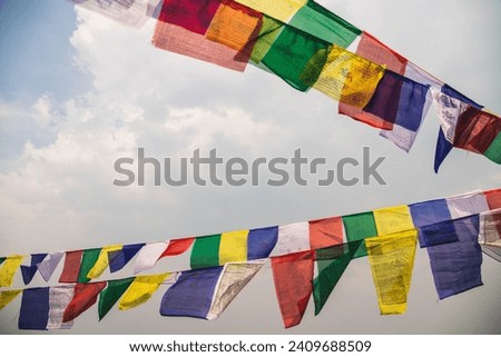 Tibetan Prayer Flags hanging with blue sky in the background - Nepal