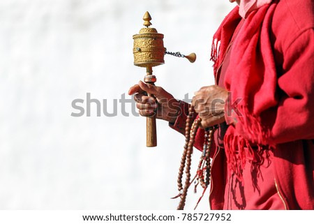 Tibetan prayer wheel in hand of old Bhutanese prayer, Thimphu, Bhutan. (Selective focus)