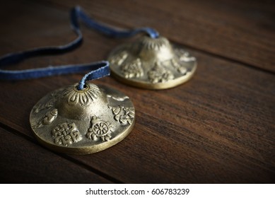 Tibetan Ting Sha Ceremonial Bells on wooden background closeup