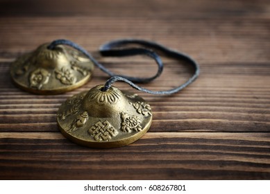 Tibetan Ting Sha Ceremonial Bells on wooden background closeup