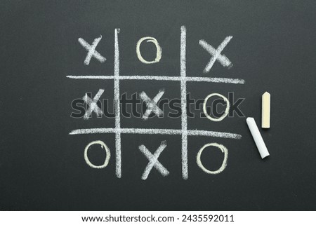 Tic tac toe game drawn on chalkboard, top view