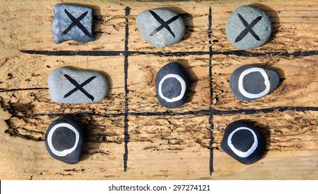 Tic tac toe game made from drift wood and rocks for outdoor garden play. 