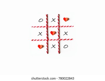 Tic tac toe game or noughts and crosses.  Red heart shaped and grid line made from paper cut,red-white rope.Flat lay,top view and white isolated.Minimal love concept.Copy space for text.Easy to use.