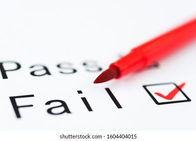 Tick boxes for Pass or Fail on paper with pen.