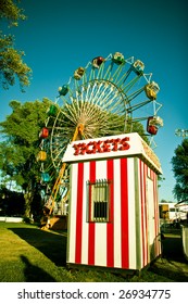 Ticket booth in front of a colorful carnival ferris wheel.