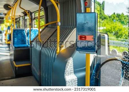 Ticket validator with empty bus interior. Public transport in a city.