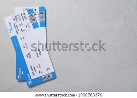 Tickets on light grey background, flat lay with space for text. Travel agency concept