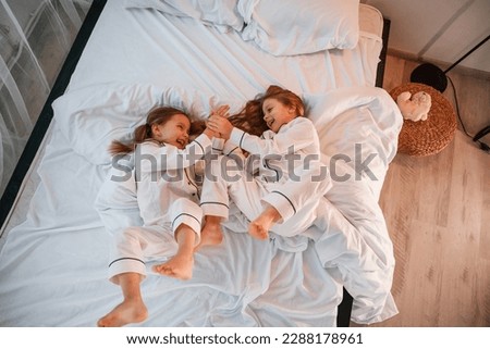 Similar – Mother reading book to her sons in the bed