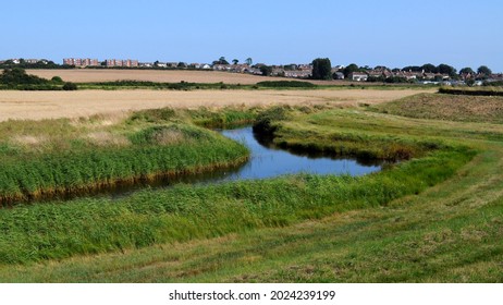 Tidal creek in The Naze Nature reserve with Walton-on-the-Naze on horizon, Essex, UK. - Shutterstock ID 2024239199