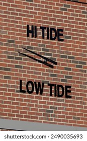 Tide Clock on the Side of a Brick Building