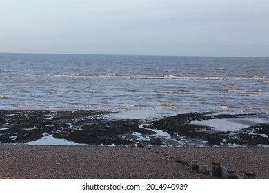 Tide Going Out On Beach With Wet Sand