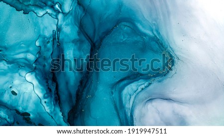 Tidewater alcohol stains of paint with the addition of gold powder. Subtle waves of paint, abstract blue waves of the ocean, lines of marble. Liquid paints, gradient stains, painting. Tinting Tidewate