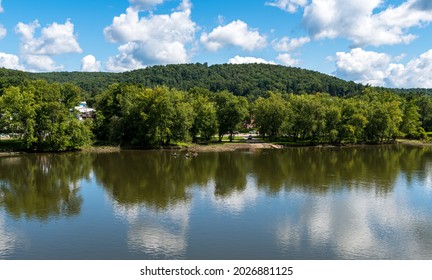 Tidioute, Pennsylvania, USA August 1, 2021 Three People Kayaking On The Allegheny River In Front Of The Tidioute Boat Ramp On A Sunny Summer Day