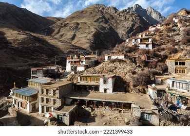 TIDRUM NUNNERY, TIBET: general view, colorful buildings on sunny hill side and tibetan prayer flags