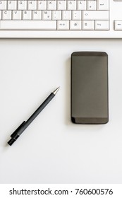 Tidy Desk With Smartphone, Pen And Computer Keyboard Photographed From Above