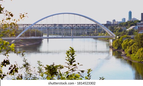 A Tied Arch Bridge Going Over A River On A Summer Day. 