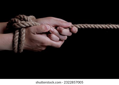 Tied hands with a rope on a black background